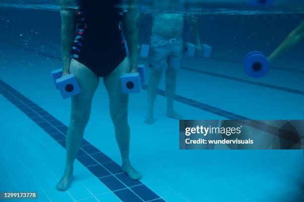 senioren wassergymnastik hanteln übung in hallenbad klasse unter wasser - aquarobics stock-fotos und bilder