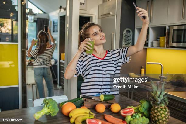 junge frau macht selfie in der küche - fruit smoothie instagram stock-fotos und bilder