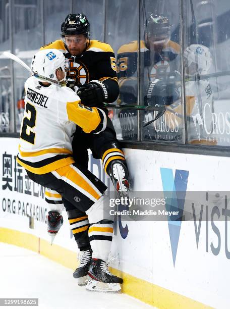 Chad Ruhwedel of the Pittsburgh Penguins checks Jeremy Lauzon of the Boston Bruins into the boards during the third period at TD Garden on January...
