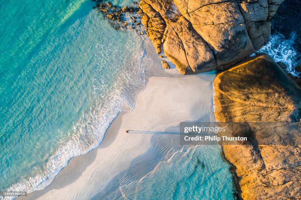 Kustlinje flygfoto av akvamarin havet och man går längs vit sandbar strand