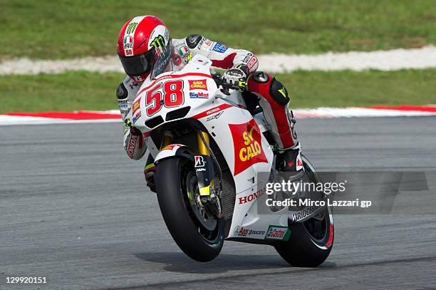 Marco Simoncelli of Italy and San Carlo Honda Gresini lifts the front wheel during the qualifying practice of MotoGP of Malaysia at Sepang Circuit on...