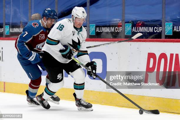 Ryan Donato of the San Jose Sharks brings the puck off the boards against Devon Toews of the Colorado Avalanche in the first period at Ball Arena on...