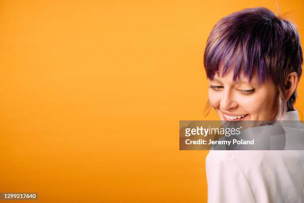 ritratto in studio di una persona alla moda, sicura di sé e bella che guarda in basso su uno sfondo giallo senape con spazio di copia - elfo pixie foto e immagini stock