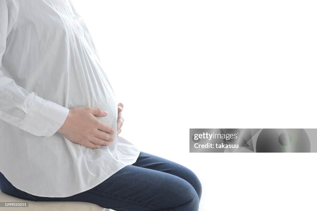 Sitting and thinking pregnant woman on white background