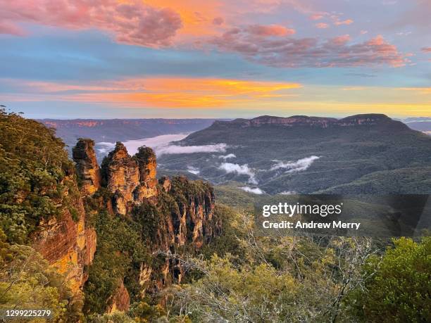 three sisters at sunset with clouds in valley, blue mountains, australia - blue mountain stock pictures, royalty-free photos & images