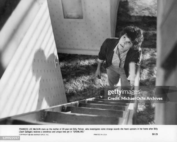 Frances Lee McCain looking up a ladder in a scene from the film 'Gremlins', 1984.