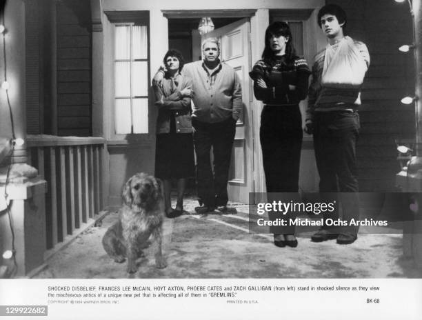 Zach Galligan, Frances Lee McCain, Hoyt Axton and Phoebe Cates all stare down the hallway at the dog in a scene from the film 'Gremlins', 1984.