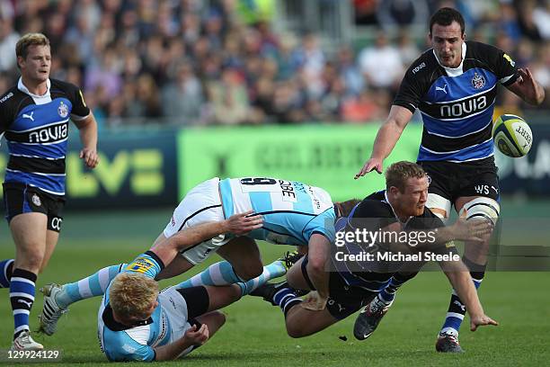 Ross Batty of Bath offloads as he is challenged by Ollie Frost and Alex Crockett of Worcester Warriors during the LV Cup match between Bath and...