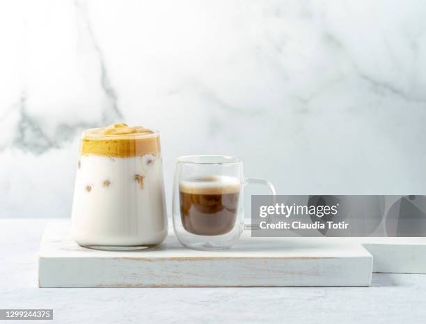 a glass of dalgona coffee and a shot of macchiato on white background - dalgona 個照片及圖片檔