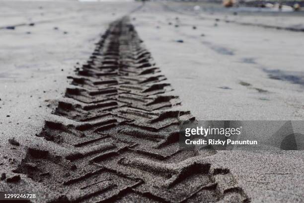 full frame shot of sand car tire tracks - bike tire tracks stockfoto's en -beelden