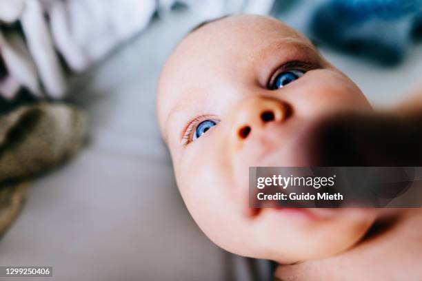 portrait of baby with blue eyes in sunlight at home. - thumb sucking stock pictures, royalty-free photos & images