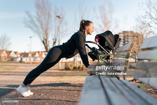 woman with baby carriage exercising outdoors - baby pram in the park stock pictures, royalty-free photos & images