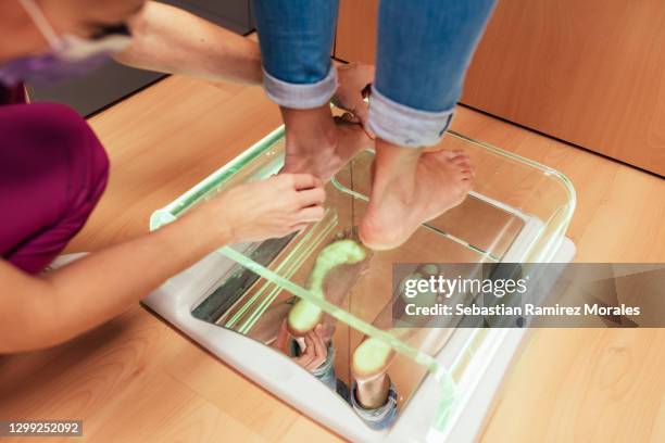 podiatrist checking a patient's feet on the podoscope - diabetes feet stock pictures, royalty-free photos & images