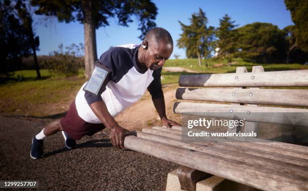 senior african-american man doing push ups on park bench - bodyweight training stock pictures, royalty-free photos & images