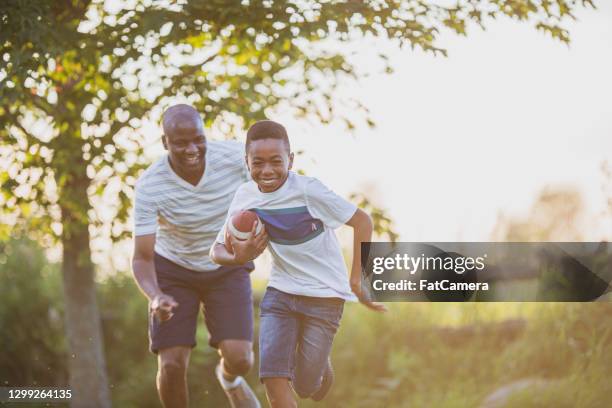 father and son playing backyard football - american football play stock pictures, royalty-free photos & images