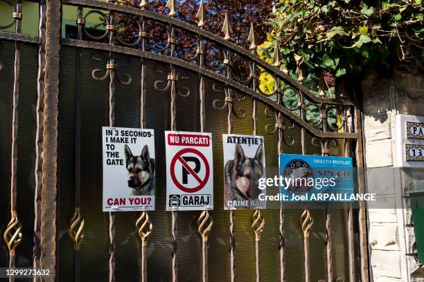 Grille avec des affiches, ne pas se garer, chien méchant et maison sous surveillance dans le quartier résidentiel de La Tomis paisible, 15 avril...