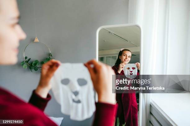 the girl put on a cosmetic cloth face mask. - cloth face mask foto e immagini stock