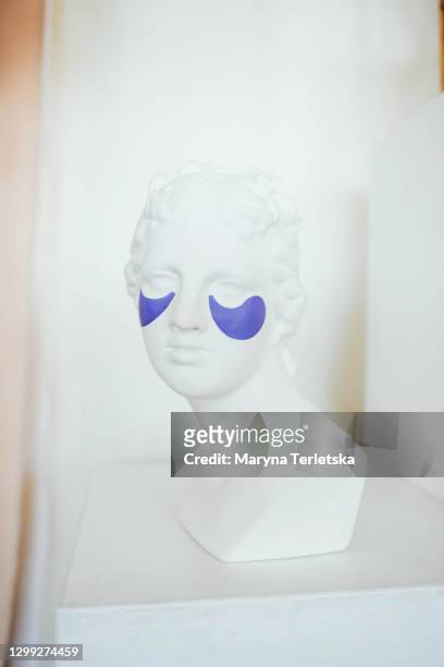 female head sculpture with cosmetic patches under the eyes. - feierliche veranstaltung stock-fotos und bilder