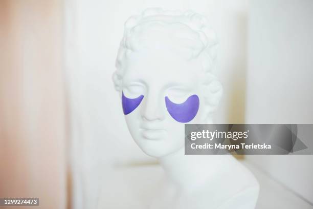 female head sculpture with cosmetic patches under the eyes. - eye patch stock pictures, royalty-free photos & images