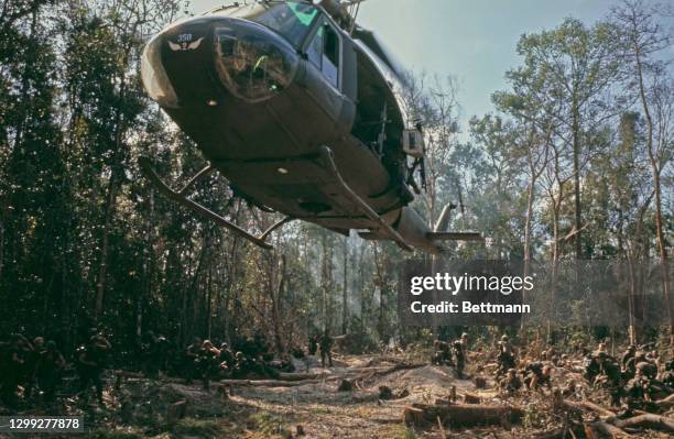 Bell UH-1 Iroquois lands in a clearing as members of the United States 1st Cavalry look on near the Cambodian border in Tay Ninh, South Vietnam, 8th...
