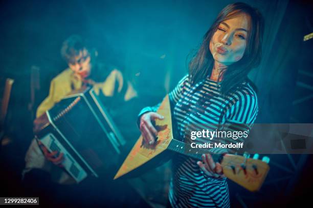 playful russian girl playing balalaika for her boyfriend zombie - balalaika stock pictures, royalty-free photos & images