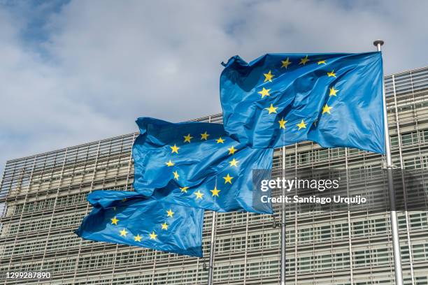 european union flags at berlaymont building of the european commission - europäische kommission stock-fotos und bilder
