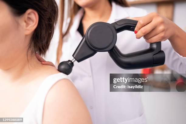 la fisioterapeuta femenina está examinando a su paciente. - zona lumbosacra fotografías e imágenes de stock