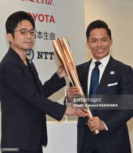 Tadahiro Nomura, triple champion olympique de judo et le designer japonais Tokujin Yoshida montrent le porte flamme olympique de Tokyo 2020 avec un...