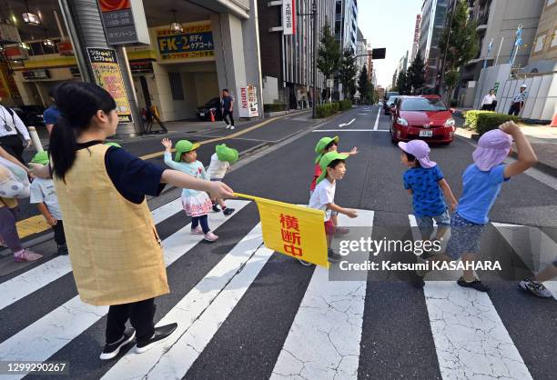 Une femme fait traverser un groupe d'enfants sur des passages piétons, 11 octobre 2019, quartier de "Toshima Ward" à Tokyo, Japon. En 2014, un groupe...