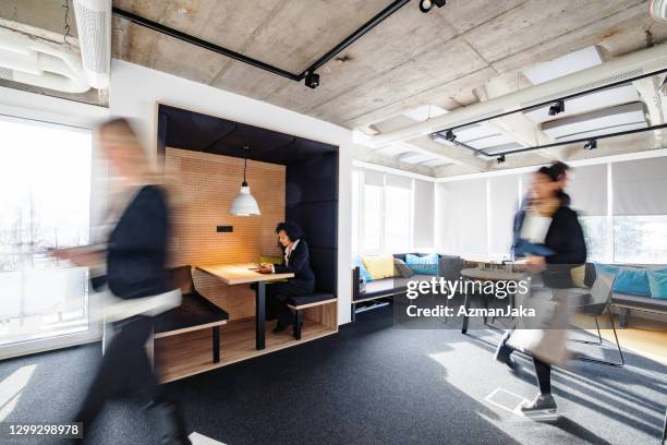 female business executives on the move and working alone - sunny office stock pictures, royalty-free photos & images