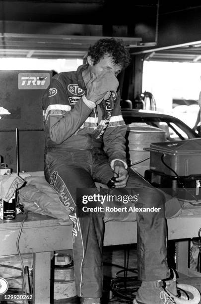 Richard Petty, driver of the STP Pontiac, rests in the Daytona International Speedway garage after qualifying for the 1983 Firecracker 400 on July 3,...