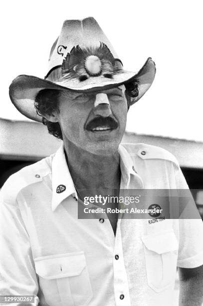 Richard Petty, driver of the STP Pontiac, walks through the Daytona International Speedway garage area after qualifying for the 1987 Firecracker 400...