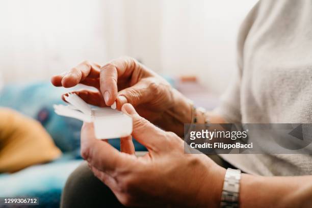 クローズアップショット成熟した女性が薬を服用し、組織 - pills ストックフォトと画像