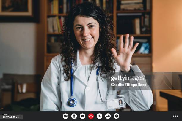 portret van een vrouwelijke arts in haar bureau, dat camera bekijkt - screenshot van een videogesprek - skypen stockfoto's en -beelden
