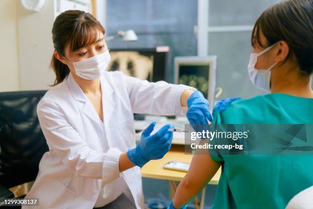 trabajadora médica vacunada en el consultorio del médico - vacuna contra la covid 19 fotografías e imágenes de stock