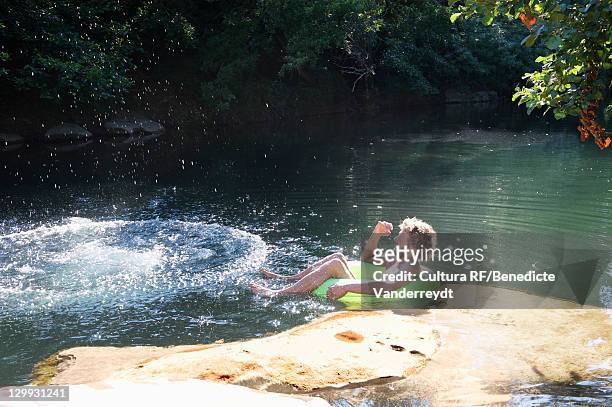 men playing in river - river tubing stock pictures, royalty-free photos & images