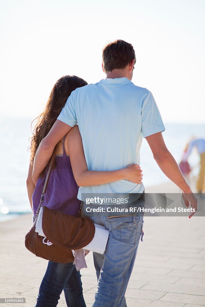 Couple walking and hugging on beach