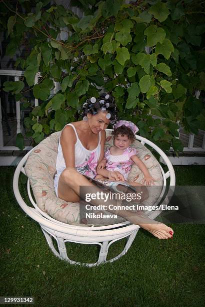 mother in curlers reading with daughter - latvia family stock pictures, royalty-free photos & images