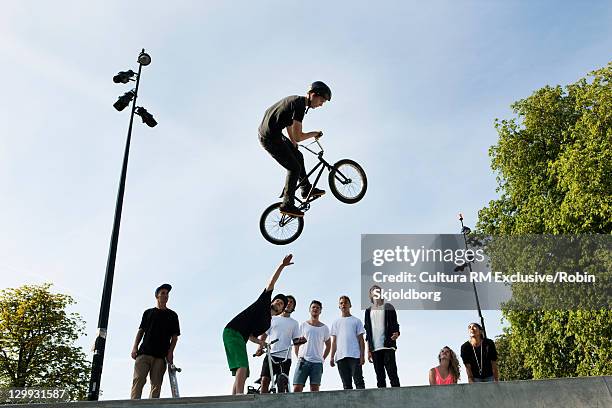 teenager doing tricks on bmx bike - bmx freestyle stock pictures, royalty-free photos & images