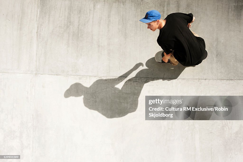 Teenager riding ramp on skateboard