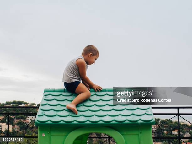 child climbed into a green toy house - casa de brinquedo imagens e fotografias de stock