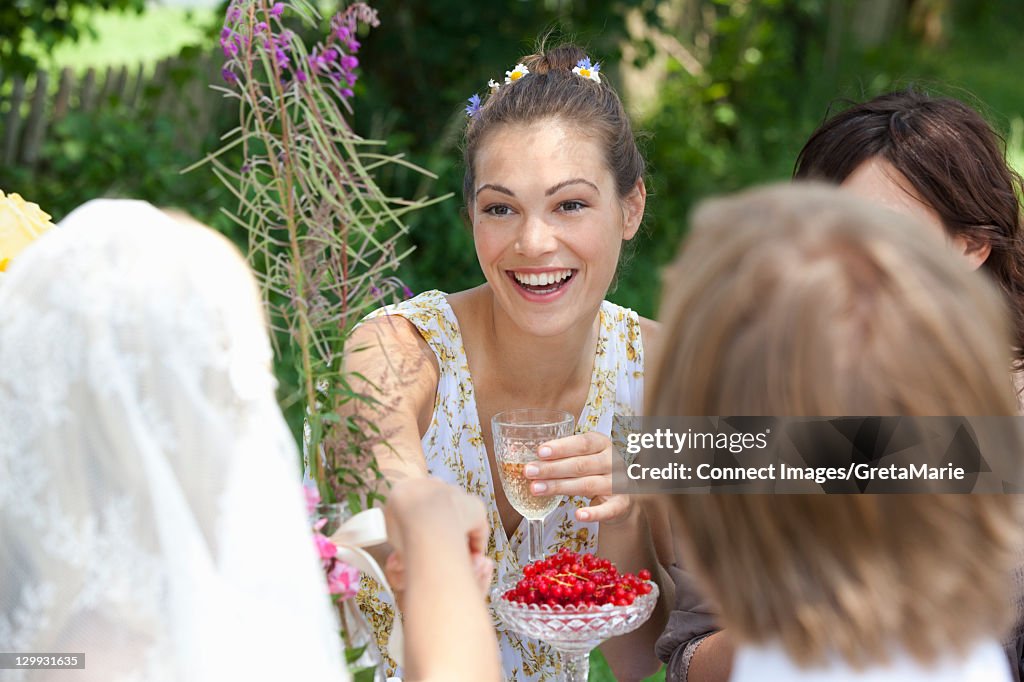 Woman drinking wine at table outdoors
