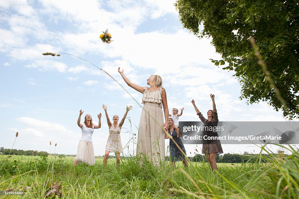 Bride tossing bouquet to wedding party