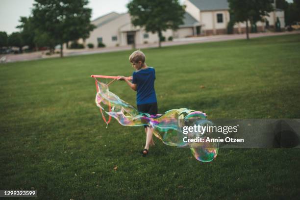 boy making big bubbles - big bubble stock-fotos und bilder