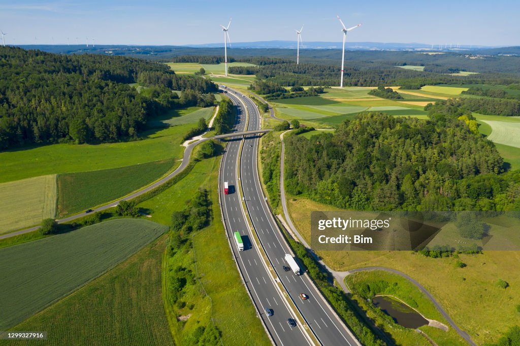 Trucks on Highway and Wind Turbines, Aerial View