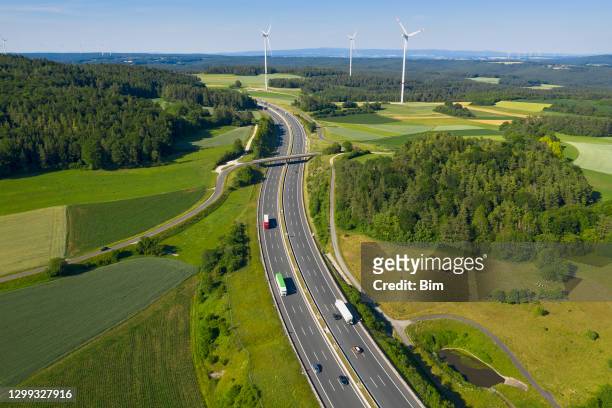 trucks on highway and wind turbines, aerial view - transportation imagens e fotografias de stock