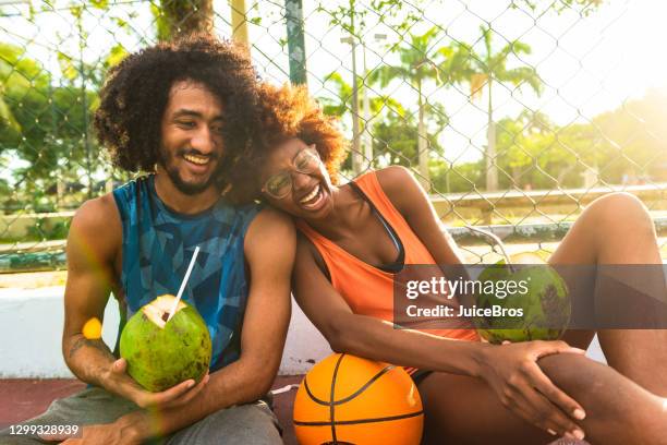 i giovani giocatori di basket riposano dopo la partita - acqua di cocco foto e immagini stock