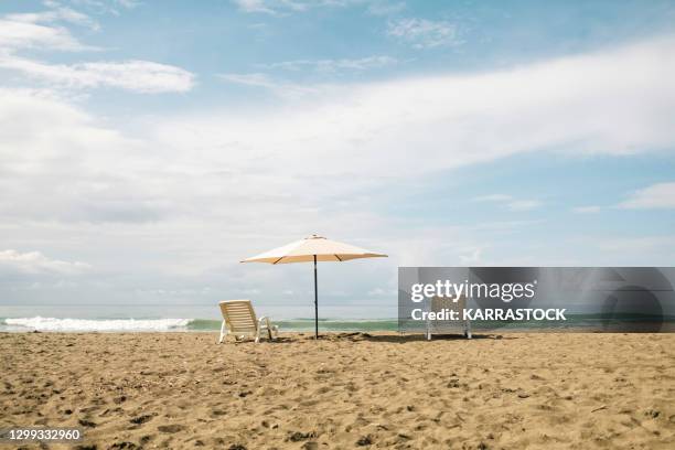 umbrella and sun loungers isolated on the beach. - cocos island costa rica fotografías e imágenes de stock