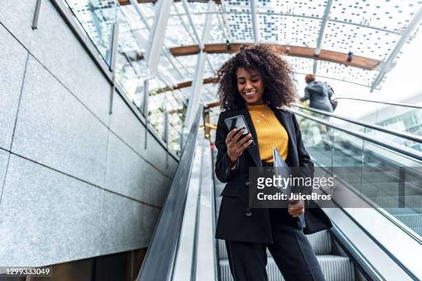 geschäftsfrau nutzt telefon in der öffentlichkeit - bankgeschäft stock-fotos und bilder