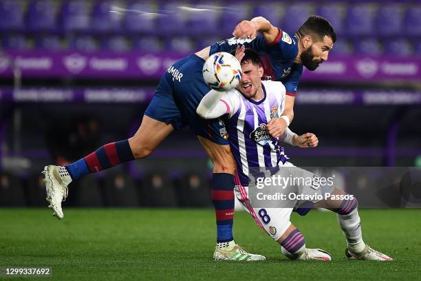 Dimitris Siovas of Huesca clashes with Kike Pérez of Real Valladolid during the La Liga Santander match between Real Valladolid CF and SD Huesca at...